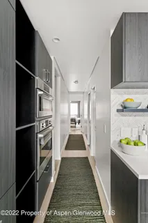 a walk in closet with wooden floor