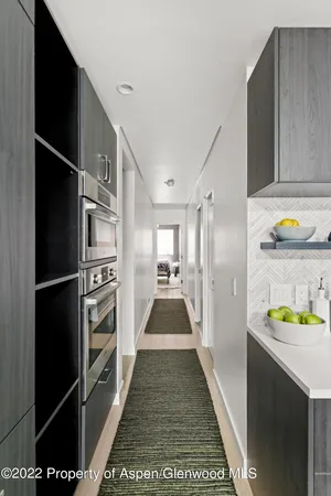 a walk in closet with wooden floor