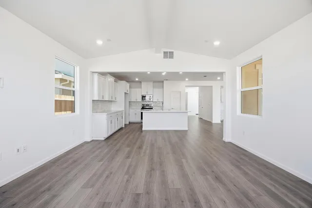 a view of a kitchen with wooden floor and windows
