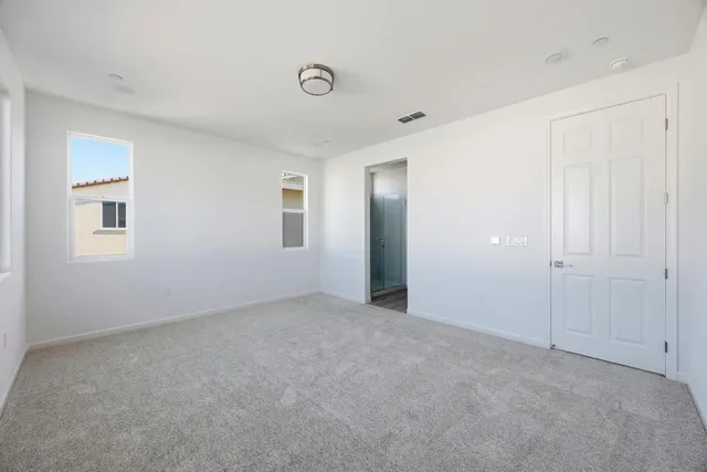 a view of an empty room with closet and a window