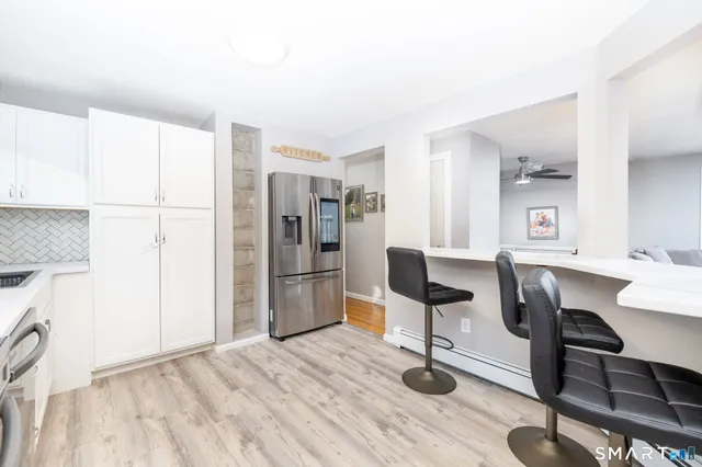 a view of a kitchen with refrigerator and dining table
