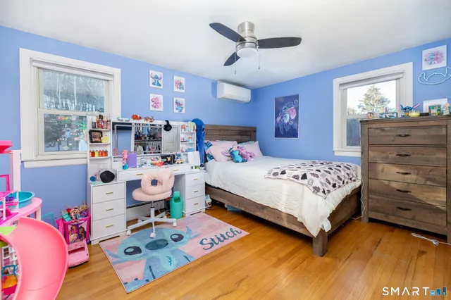 a bedroom with a bed a dresser and next to a window