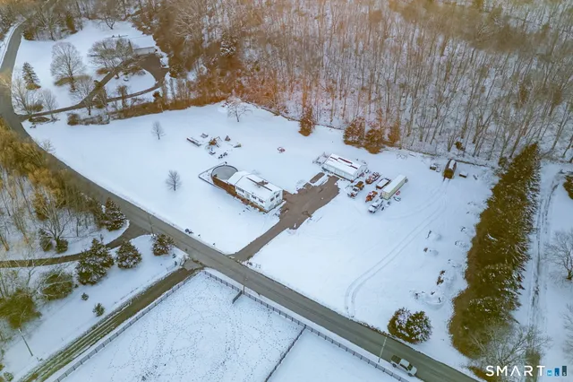 an aerial view of a house a yard and a wooden bench