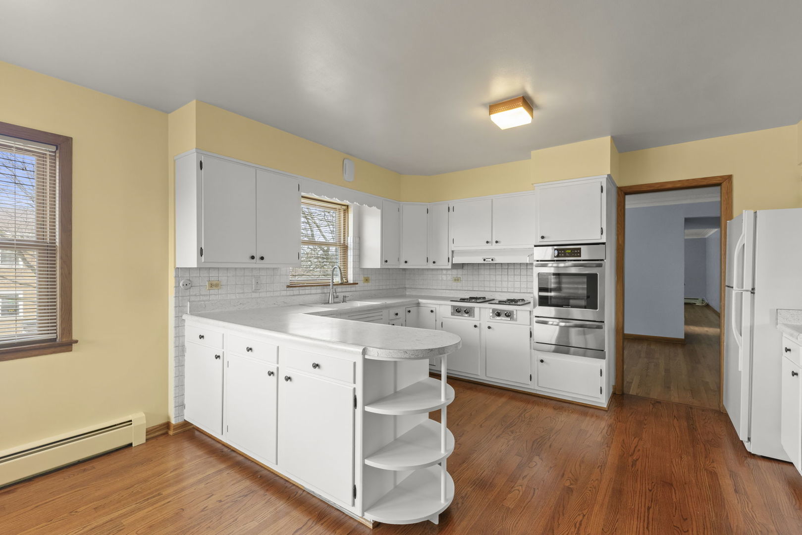 6401 West 52nd Street, Unit 2 Chicago, IL 60638 - Photo 2 of 18 a kitchen with a refrigerator a sink and wooden floor
