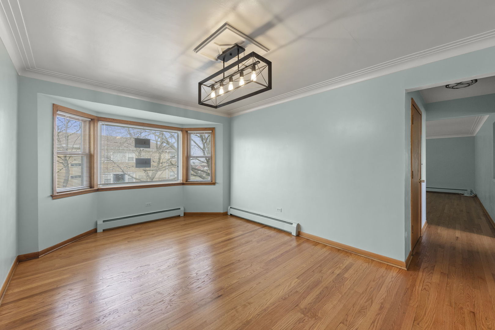 6401 West 52nd Street, Unit 2 Chicago, IL 60638 - Photo 7 of 18 an empty room with wooden floor and windows