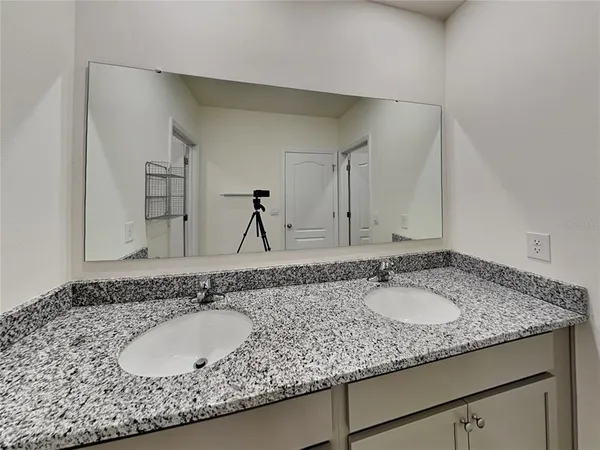 a bathroom with a granite countertop sink and a mirror