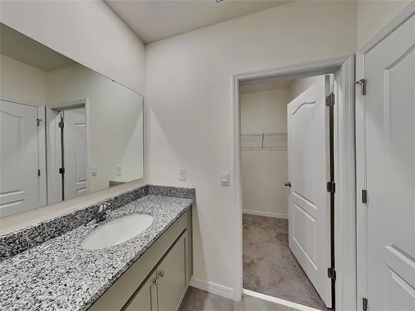 a bathroom with a granite countertop sink and a mirror