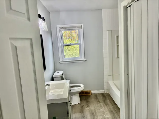 a bathroom with a granite countertop toilet and a shower curtain