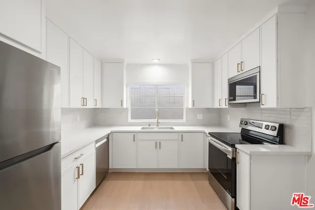a kitchen with a sink a stove and cabinets