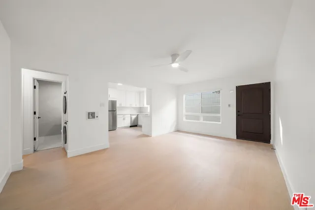 a view of empty room with kitchen and window