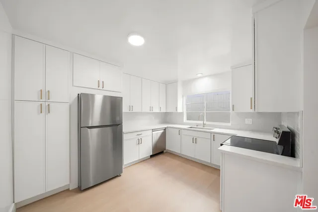 a kitchen with a refrigerator a sink and cabinets