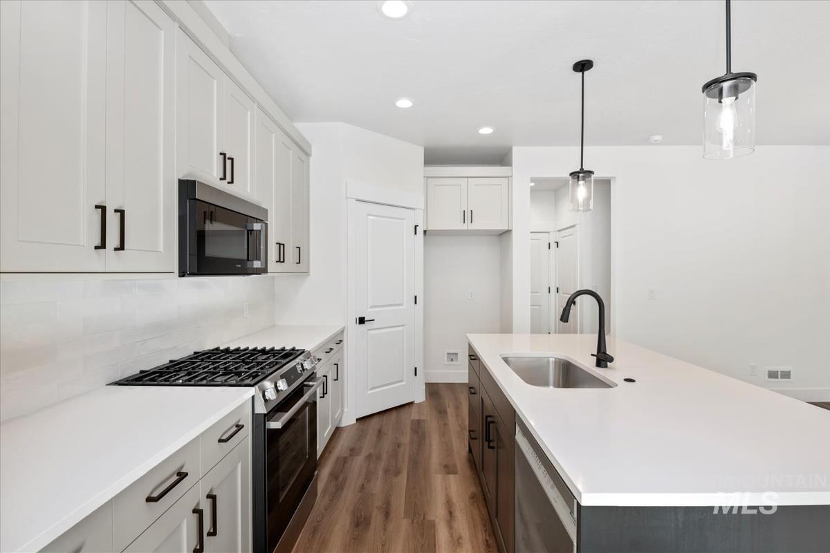 752 South Calhoun Lane Star, ID 83669 - Photo 10 of 45 Contemporary kitchen featuring white shaker cabinetry, a white subway tile backsplash, and wood-finish flooring