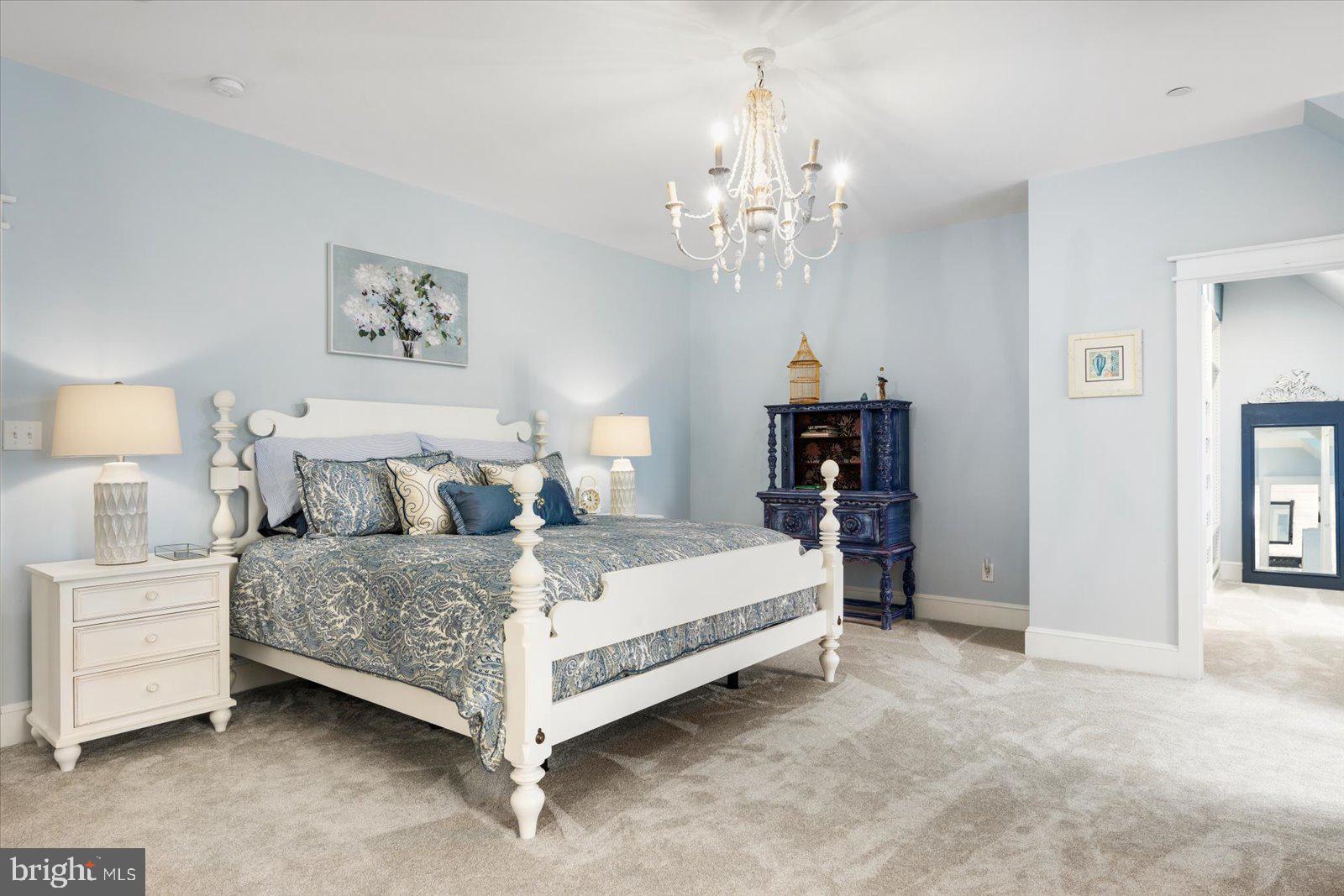 828 Federal Hill Road Street, MD 21154 - Photo 47 of 73 a spacious bedroom with bed and a chandelier