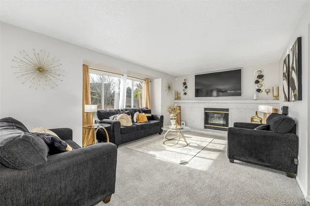 a living room with furniture a fireplace and a flat screen tv