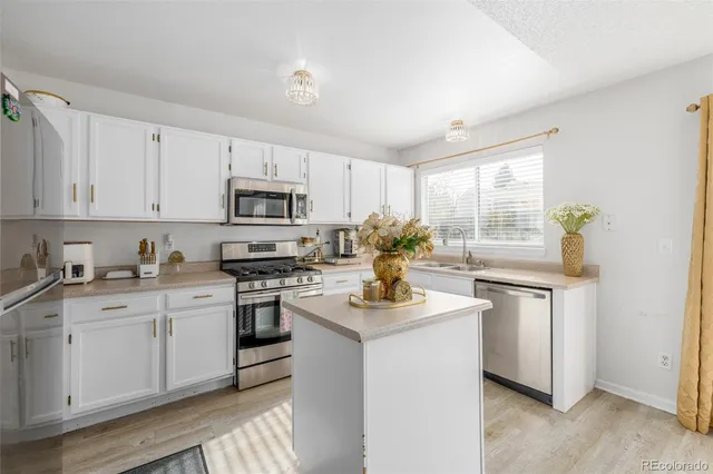 a kitchen with granite countertop white cabinets and white appliances