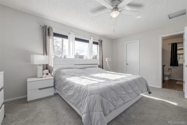 a spacious bedroom with a bed and a chandelier