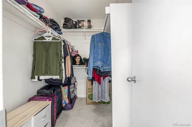 a view of walk in closet with clothes
