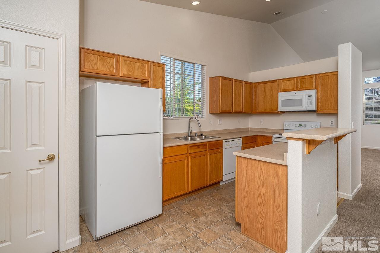 9025 Andraste Way Reno, NV 89506 - Photo 15 of 31 a kitchen with stainless steel appliances granite countertop a refrigerator sink stove and microwave