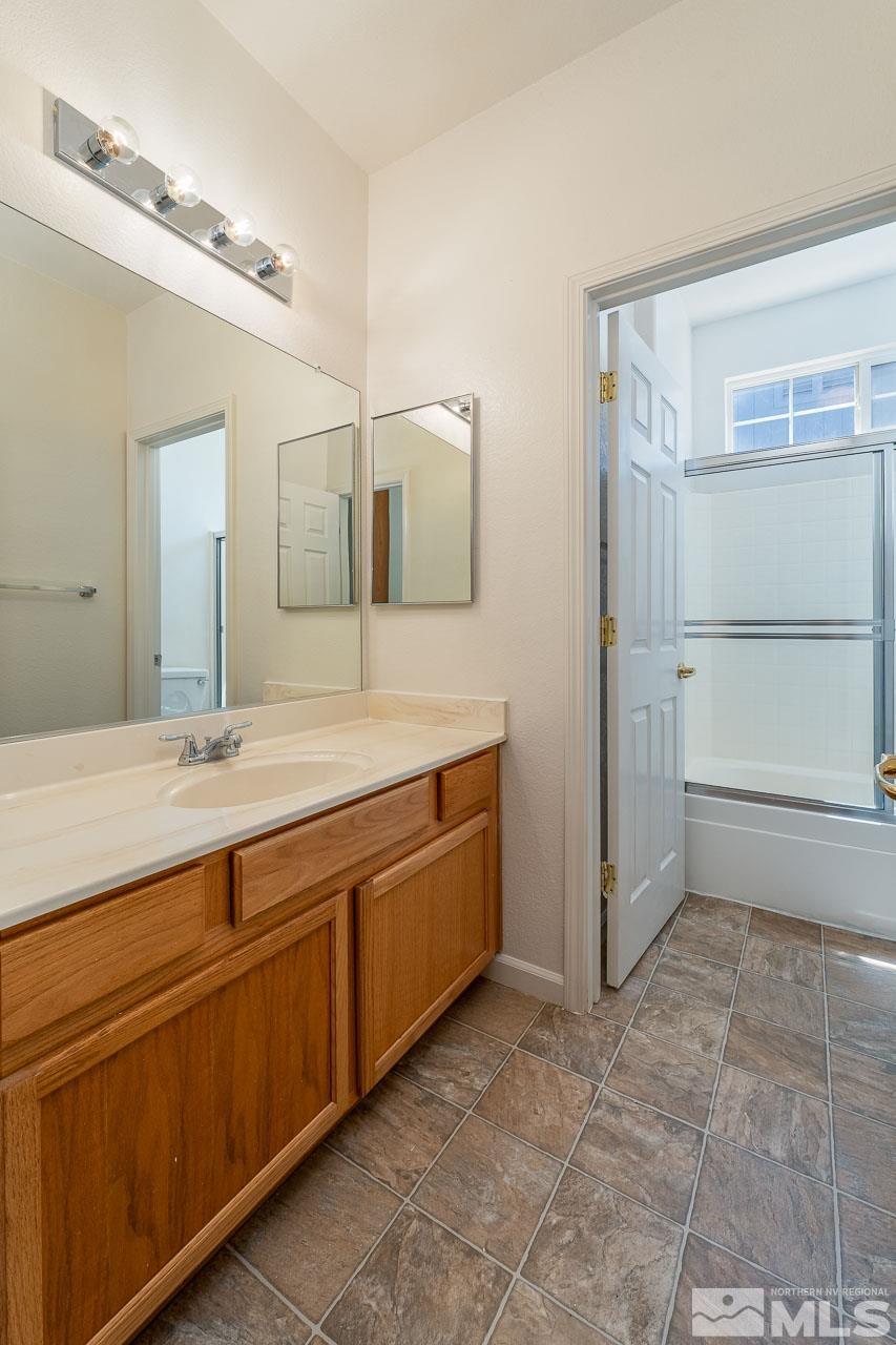 9025 Andraste Way Reno, NV 89506 - Photo 24 of 31 a spacious bathroom with a granite countertop sink a mirror and a