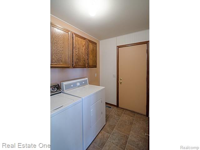7555 Rattalee Lake Road Clarkston, MI 48348 - Photo 26 of 41 First floor laundry room, with cabinets and door to backyard deck.