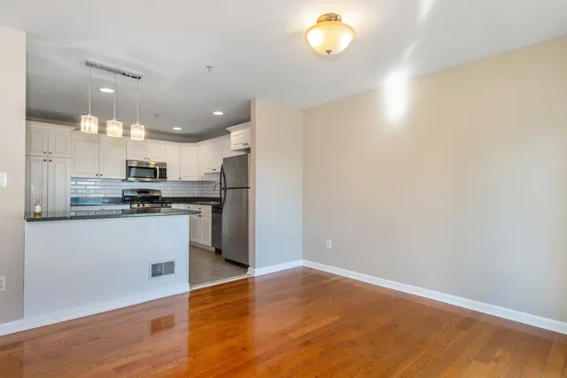 a kitchen with a refrigerator and a stove top oven