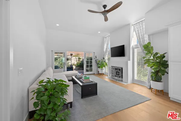 a bedroom with a bed a flat screen tv and a potted plant
