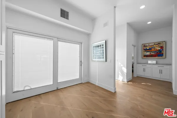 a large kitchen with stainless steel appliances a large counter top a stove and a sink