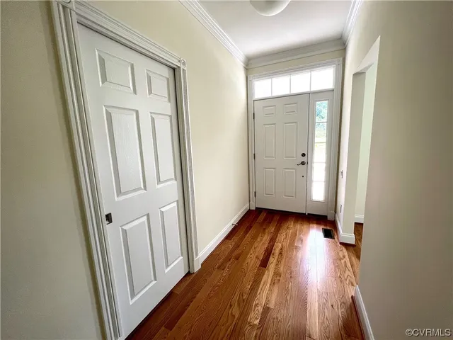 a view of a room with wooden floor and entryway