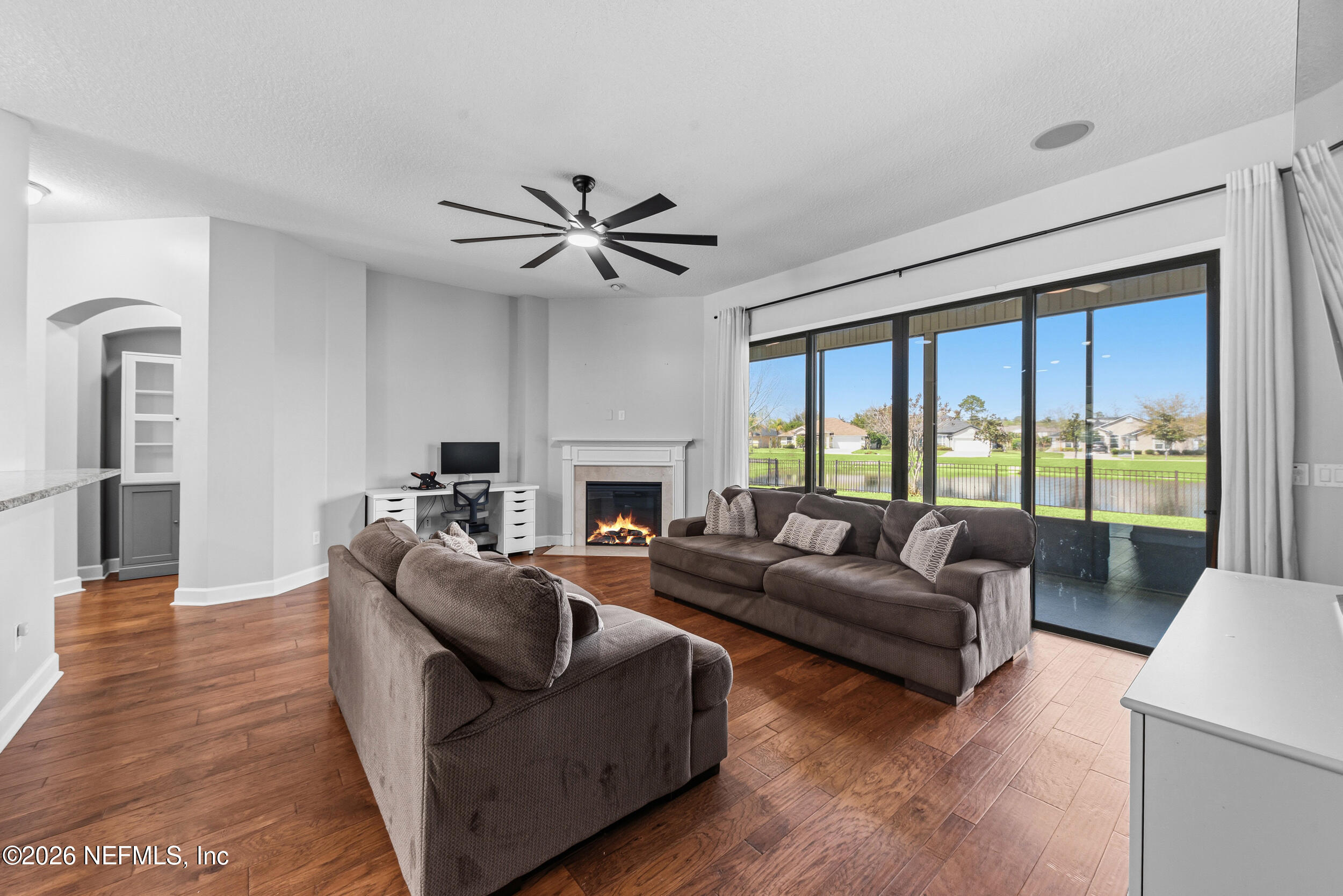 109 Cummer Way St. Augustine, FL 32095 - Photo 16 of 42 a living room with furniture a large window a fireplace and a flat screen tv