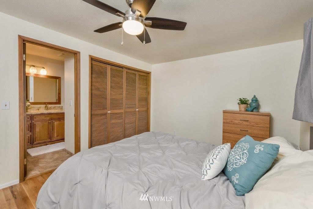12525 Southeast 99th Street Renton, WA 98056 - Photo 17 of 33 a bedroom with a large bed and a chandelier