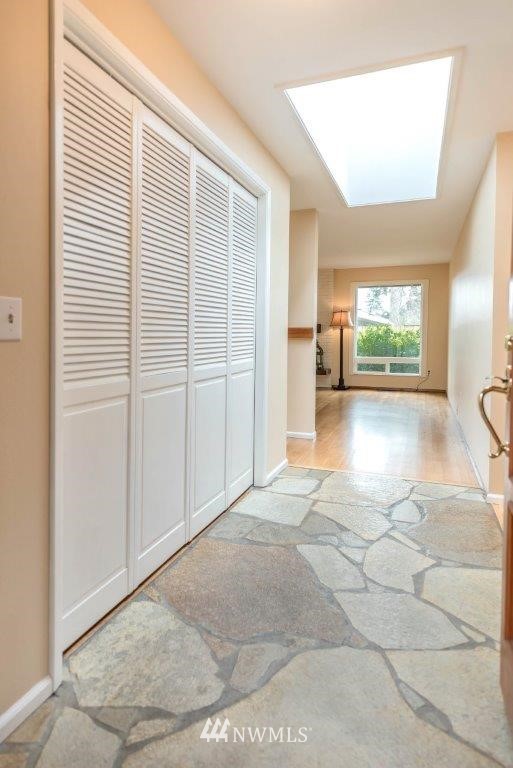 12525 Southeast 99th Street Renton, WA 98056 - Photo 4 of 33 a view of a hallway with wooden floor and a living room