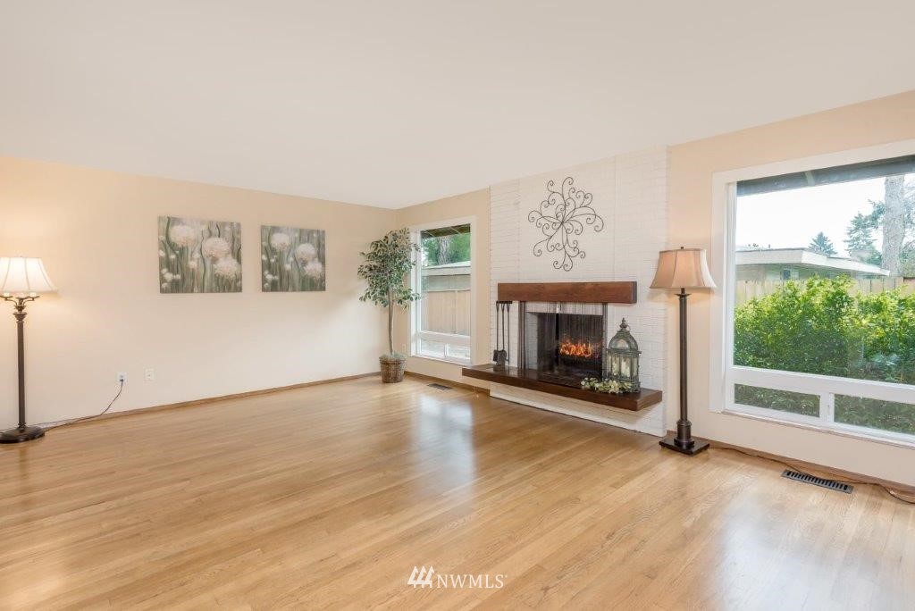12525 Southeast 99th Street Renton, WA 98056 - Photo 6 of 33 an empty room with windows fireplace and wooden floor