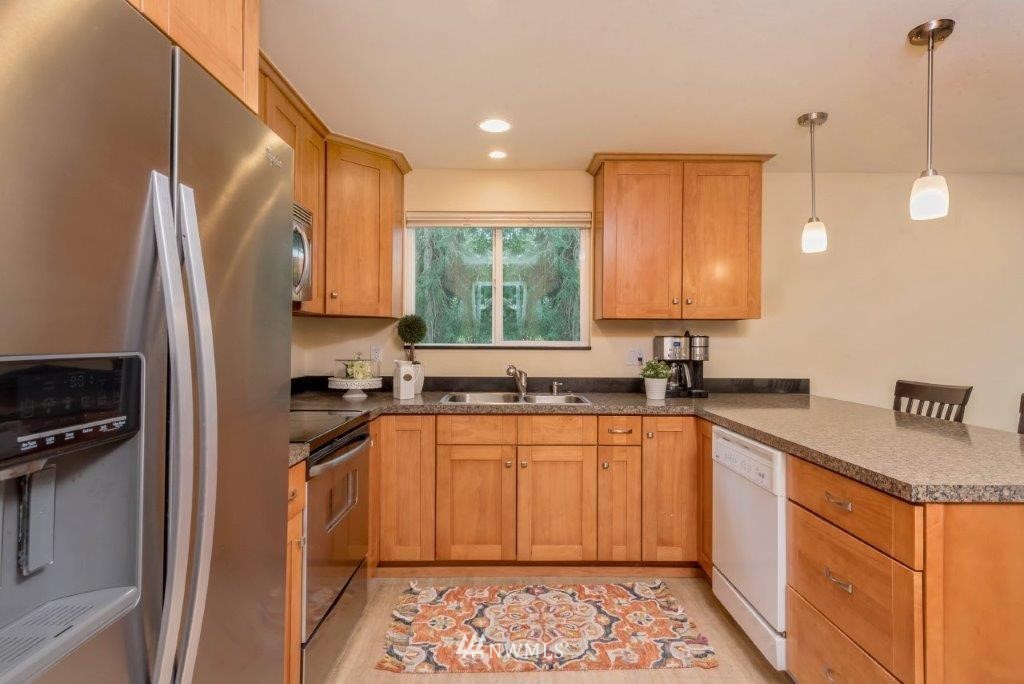 12525 Southeast 99th Street Renton, WA 98056 - Photo 9 of 33 a kitchen with stainless steel appliances granite countertop a sink stove and refrigerator