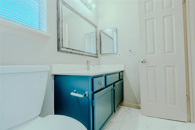 a bathroom with a toilet sink and mirror