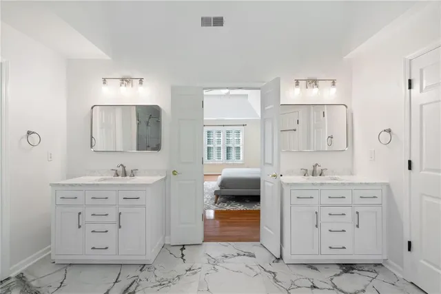 a bedroom with a large bed and a potted plant