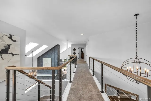 a view of staircase with lots of frames on wall and a window
