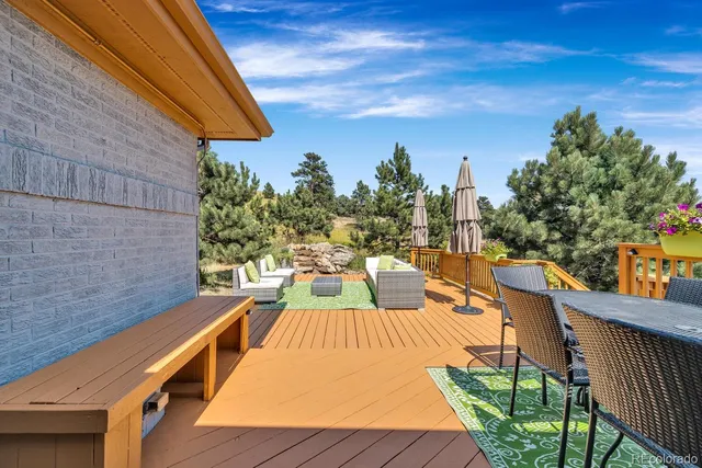 a view of a patio with table and chairs with wooden floor and fence