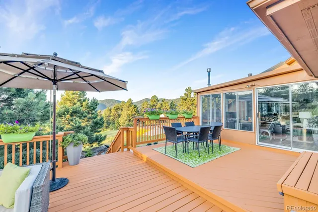 a view of a patio with couches chairs potted plants and wooden floor