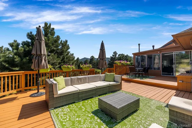 a view of a roof deck with couches and sky view