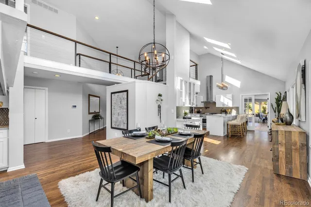 a view of a a dining room with furniture wooden floor and a chandelier