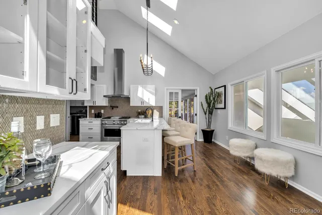 a kitchen with a dining table chairs and white cabinets