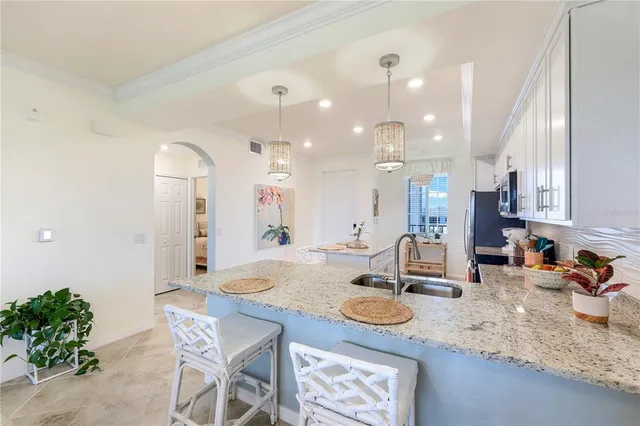 a kitchen with sink refrigerator dining table and chairs