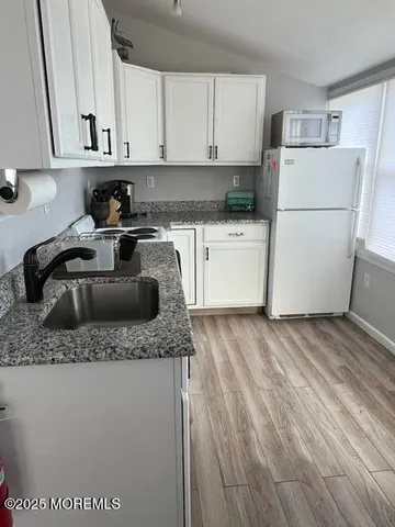 a kitchen with a refrigerator sink and cabinets
