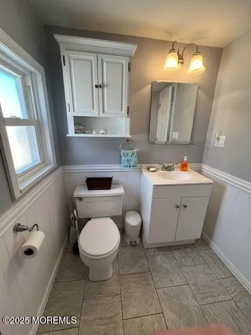 a bathroom with a toilet sink and mirror
