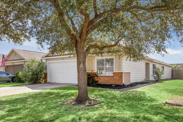 a view of a house with backyard and a tree