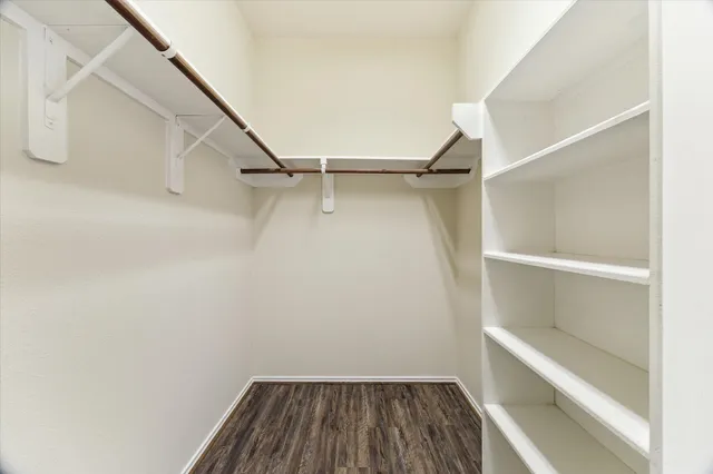 a view of walk in closet with empty racks