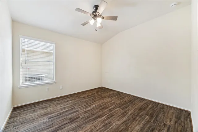 an empty room with a window and a ceiling fan