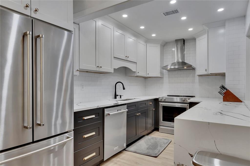 a kitchen with stainless steel appliances granite countertop a refrigerator sink and stove