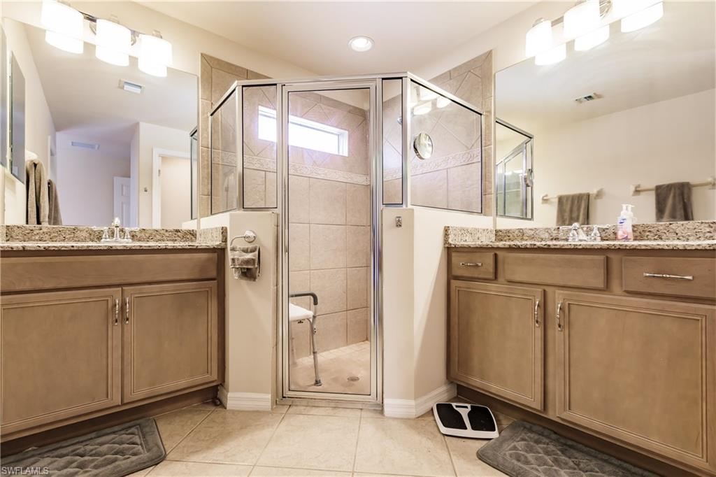 19628 Villa Rosa Loop Estero, FL 33967 - Photo 17 of 25 a bathroom with a granite countertop sink a mirror and a shower