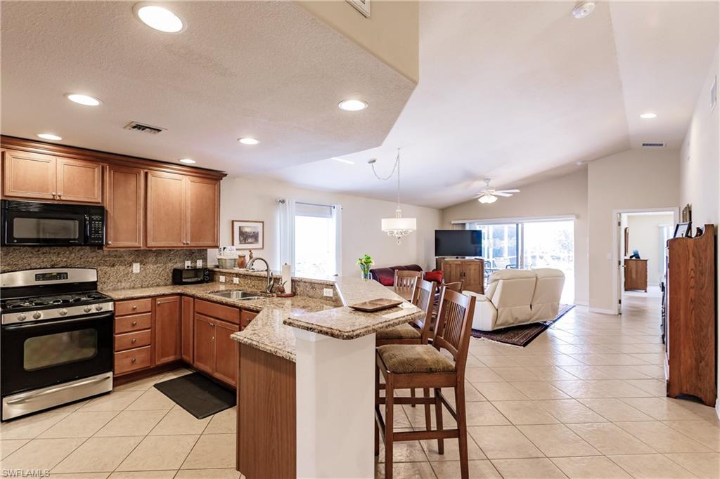 19628 Villa Rosa Loop Estero, FL 33967 - Photo 5 of 25 a kitchen with stainless steel appliances kitchen island granite countertop a sink and cabinets
